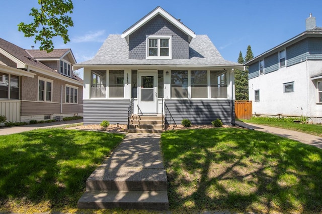 1449 Laurel Ave, Saint Paul, MN 55104 - bungalow-style home featuring entry steps, a front yard, a sunroom, and roof with shingles