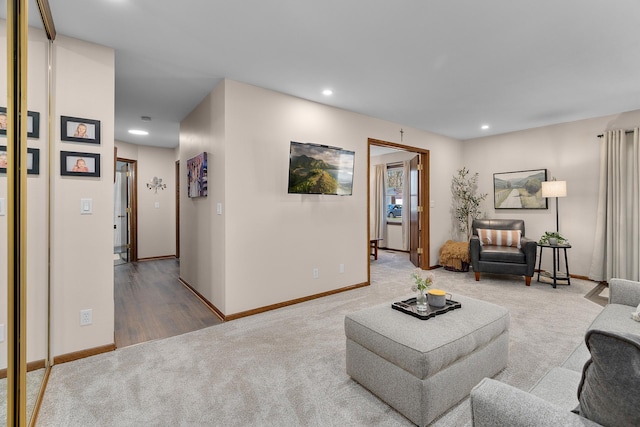 carpeted living area with recessed lighting, baseboards, and wood finished floors