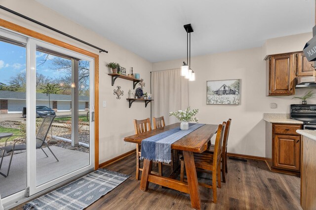 dining area with baseboards and dark wood finished floors
