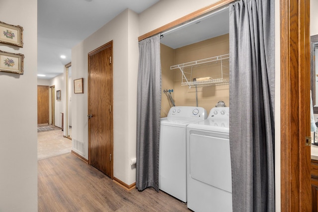 laundry room with washer and dryer, laundry area, baseboards, wood finished floors, and visible vents