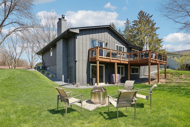 17725 26th Ave N, Plymouth, MN 55447 - rear view of property featuring board and batten siding, a deck, a chimney, a yard, and a fire pit