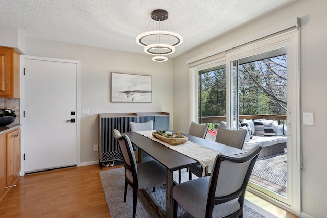 17725 26th Ave N, Plymouth, MN 55447 - dining area with light wood-style floors, a textured ceiling, and a chandelier