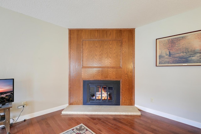 unfurnished living room with baseboards, wood finished floors, and a fireplace