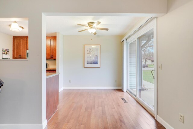 interior space with ceiling fan, visible vents, plenty of natural light, and light wood-type flooring