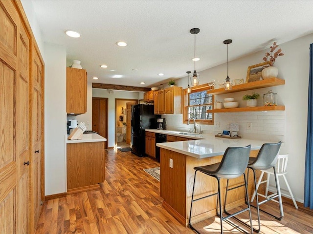 14898 Lynndale Ln, Baxter, MN 56425 - kitchen with black appliances, a sink, light wood-style floors, light countertops, and a peninsula
