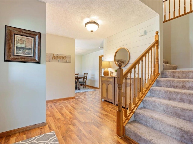 14898 Lynndale Ln, Baxter, MN 56425 - staircase featuring wood finished floors, baseboards, and a textured ceiling