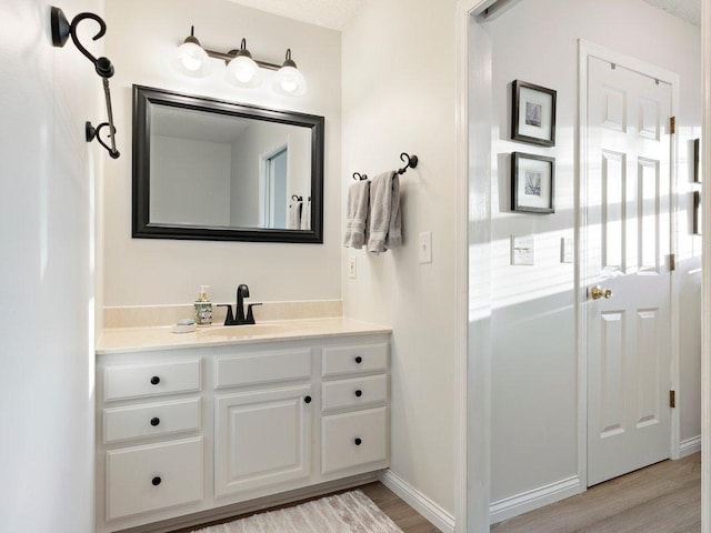 14898 Lynndale Ln, Baxter, MN 56425 - bathroom with wood finished floors, vanity, and baseboards