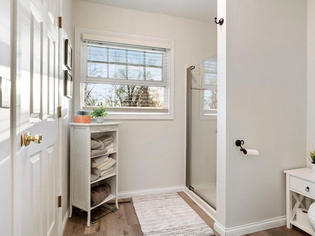 14898 Lynndale Ln, Baxter, MN 56425 - bathroom featuring a stall shower, wood finished floors, and baseboards