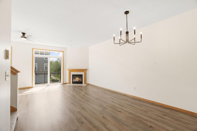 5030 Yuma Ln N, Plymouth, MN 55446 - unfurnished living room featuring wood finished floors, a chandelier, baseboards, a fireplace with flush hearth, and ceiling fan