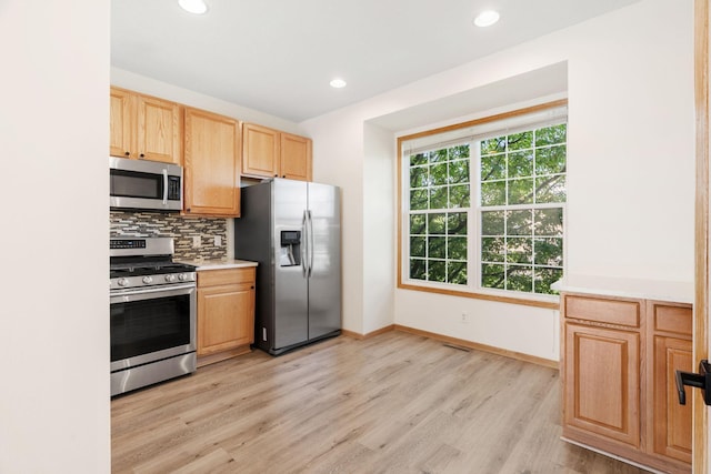 5030 Yuma Ln N, Plymouth, MN 55446 - kitchen with appliances with stainless steel finishes, light brown cabinets, light wood finished floors, decorative backsplash, and recessed lighting