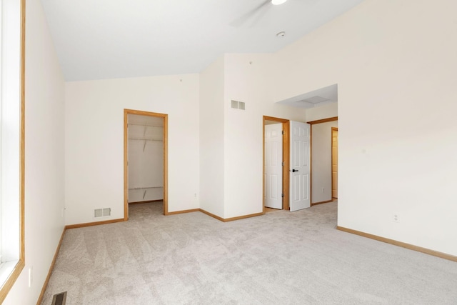 5030 Yuma Ln N, Plymouth, MN 55446 - unfurnished bedroom featuring light carpet, lofted ceiling, baseboards, and a walk in closet
