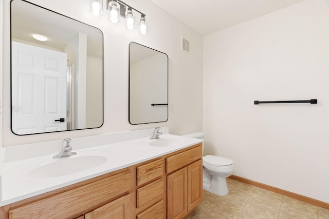 5030 Yuma Ln N, Plymouth, MN 55446 - bathroom with toilet, double vanity, and baseboards