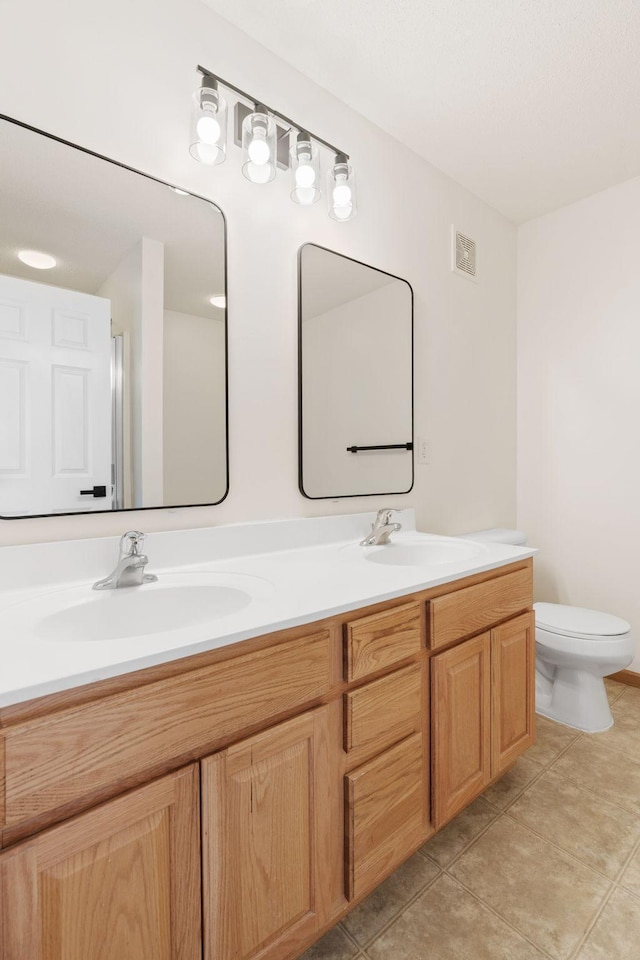 5030 Yuma Ln N, Plymouth, MN 55446 - bathroom with toilet, double vanity, and tile patterned flooring