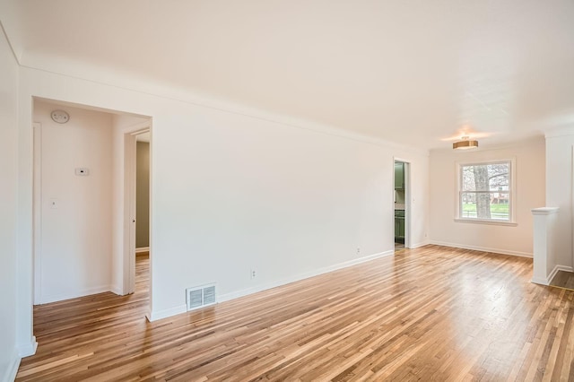 spare room featuring baseboards, visible vents, and light wood-style flooring