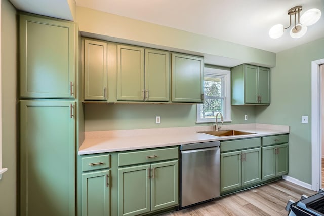 kitchen with light wood-type flooring, dishwasher, a sink, light countertops, and green cabinetry