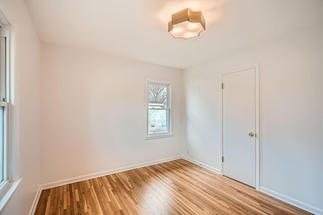 empty room featuring baseboards and light wood finished floors