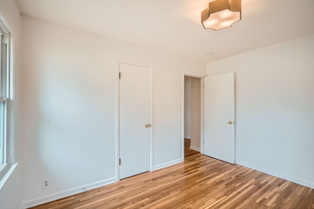 unfurnished bedroom featuring light wood-type flooring and baseboards