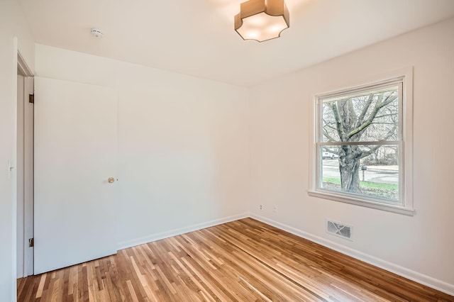 unfurnished room with visible vents, light wood-style floors, and baseboards
