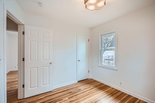 unfurnished bedroom with baseboards and light wood finished floors