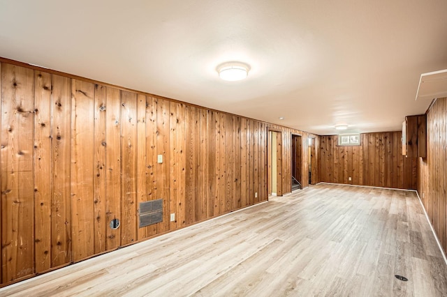 finished basement with wood walls, wood finished floors, and visible vents