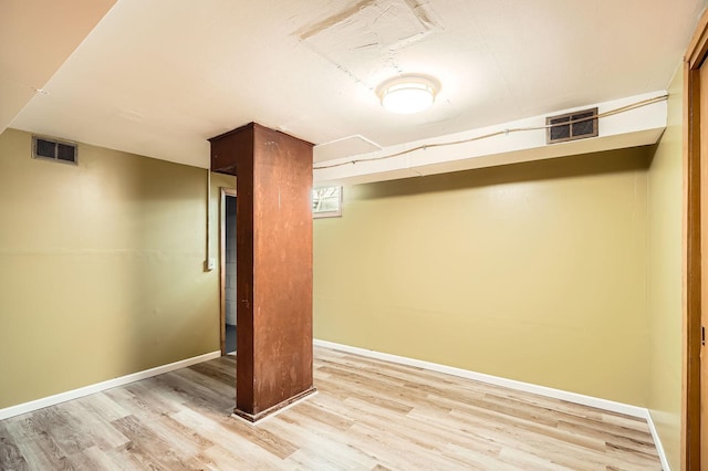 finished basement featuring baseboards, wood finished floors, and visible vents