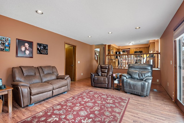 living area with recessed lighting and light wood-style floors