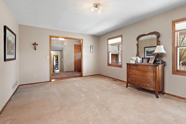 interior space featuring baseboards, visible vents, and carpet
