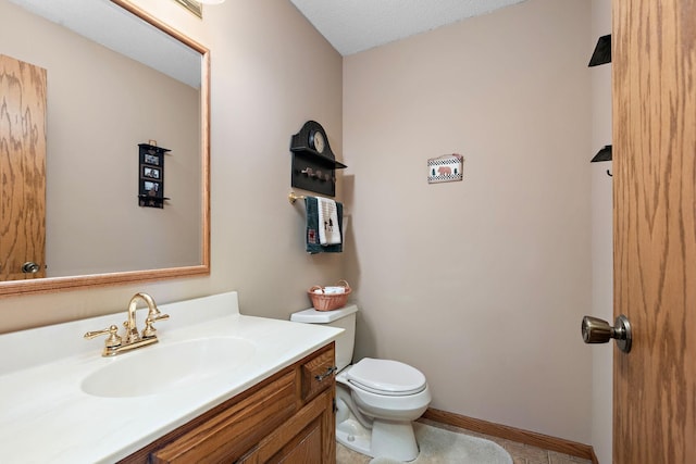 bathroom with vanity, tile patterned floors, baseboards, and toilet