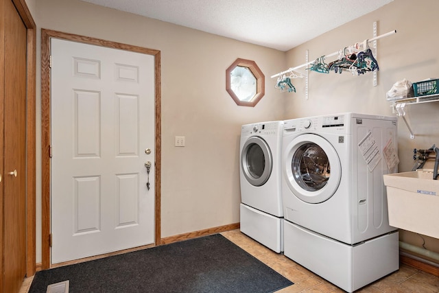 laundry area featuring a sink, laundry area, washing machine and dryer, and a textured ceiling
