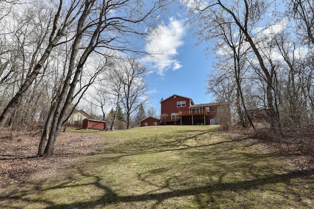 view of yard featuring a deck and an outbuilding