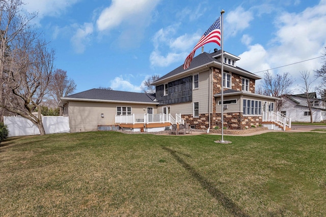 131 Norman Ave N, Foley, MN 56329 - back of property featuring fence, a yard, stone siding, and a deck