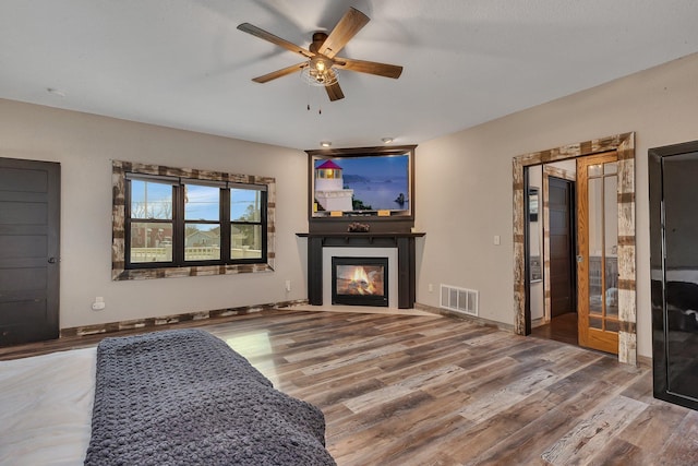 131 Norman Ave N, Foley, MN 56329 - living area featuring ceiling fan, visible vents, a fireplace with flush hearth, and wood finished floors