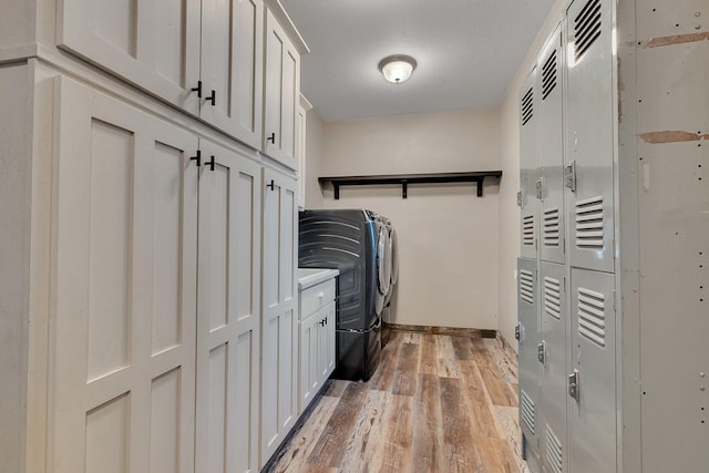 131 Norman Ave N, Foley, MN 56329 - clothes washing area with light wood-style floors, baseboards, cabinet space, and washer and dryer