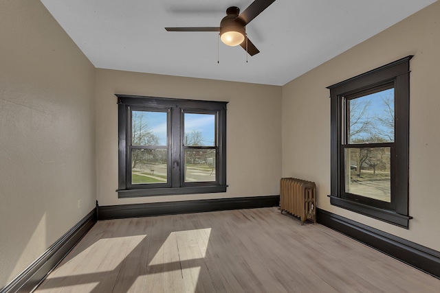 131 Norman Ave N, Foley, MN 56329 - spare room featuring radiator heating unit, baseboards, ceiling fan, and wood finished floors