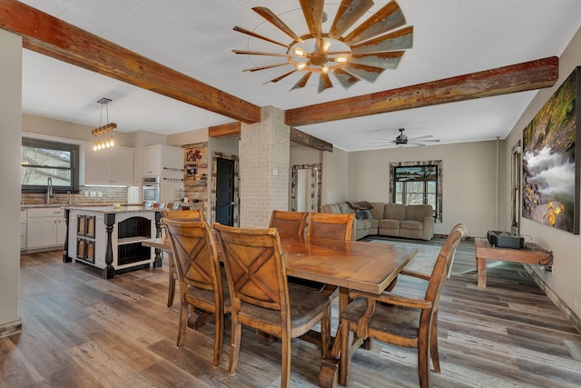 131 Norman Ave N, Foley, MN 56329 - dining room featuring ceiling fan, plenty of natural light, beam ceiling, and dark wood-type flooring