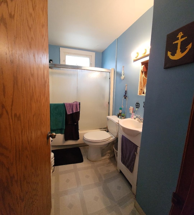 211 2nd St, Albert Lea, MN 56007 - bathroom featuring tile patterned floors, vanity, bath / shower combo with glass door, and toilet