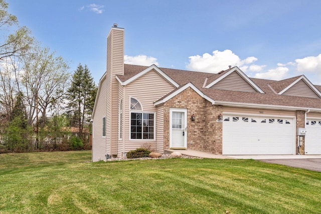 view of front of property with an attached garage, a chimney, a shingled roof, and a front lawn