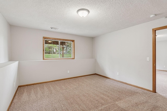 empty room with visible vents, carpet flooring, and a textured ceiling
