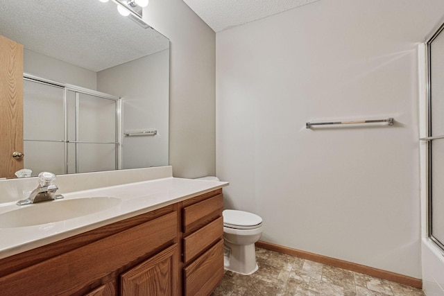 bathroom with vanity, toilet, baseboards, a textured ceiling, and a shower with shower door