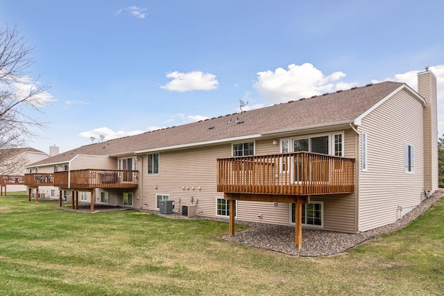 back of property with a chimney, a lawn, central air condition unit, and a wooden deck
