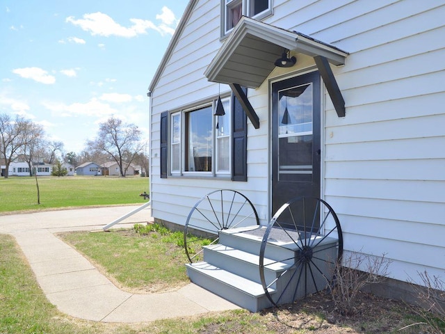 property entrance with a lawn