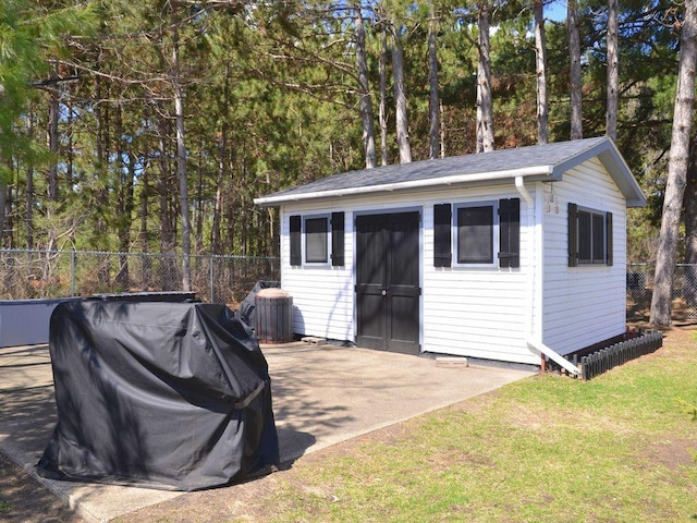 view of outbuilding with fence and an outbuilding