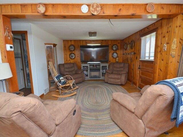 living room featuring visible vents, baseboards, and wooden walls