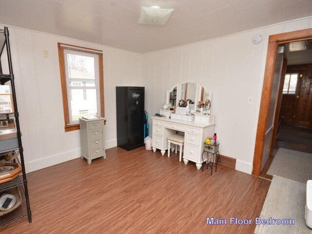 office area featuring baseboards, light wood-style flooring, and a decorative wall