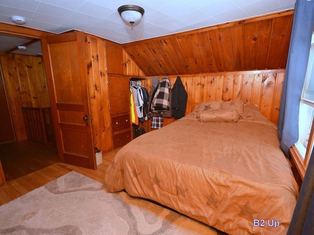 bedroom with wooden walls and wood finished floors