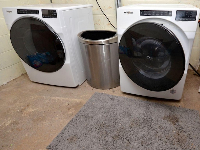 washroom with washing machine and dryer and concrete block wall