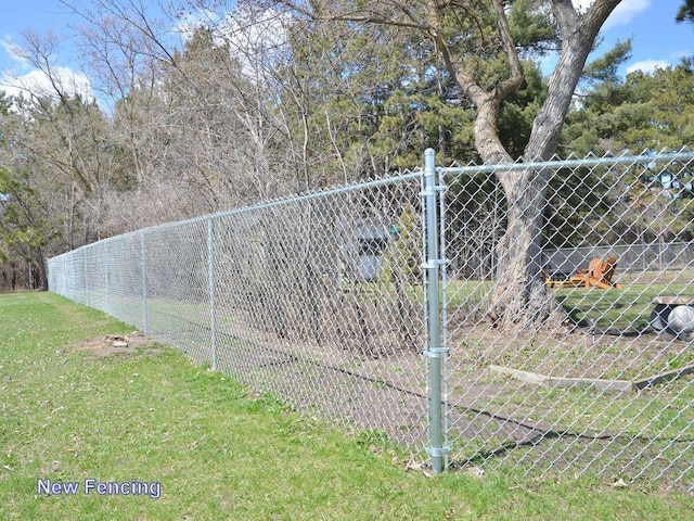 view of gate with a yard and fence