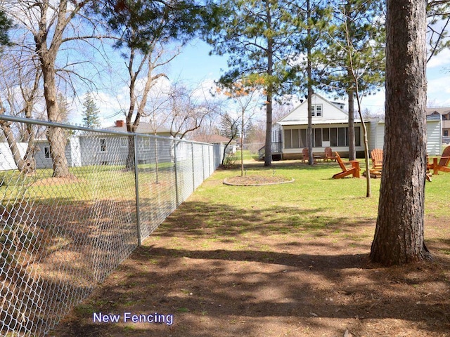 view of yard featuring fence and a sunroom