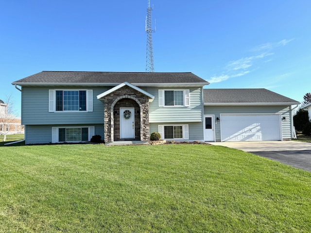 bi-level home featuring a garage, driveway, and a front yard