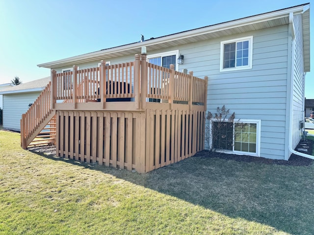 back of property featuring a lawn, a wooden deck, and stairs